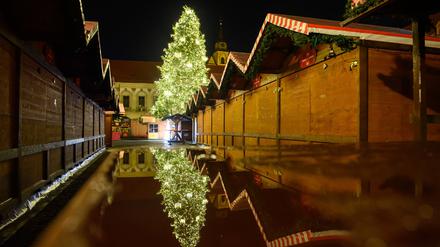 Der Weihnachtsbaum des Weihnachtsmarktes spiegelt sich auf einer regennassen Tischplatte. Am 20. Dezember 2024 war auf dem Weihnachtsmarkt ein Autofahrer in eine Menschengruppe gefahren. 