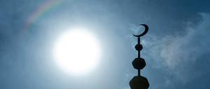 Der Halbmond auf dem Minarett einer Moschee hebt sich  als Schattenriss vor der Sonne ab. (Symbolbild)