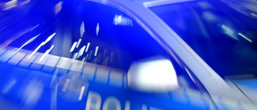 Ein Streifenwagen fährt mit eingeschaltetem Blaulicht durch die Nacht. (Symbolbild)
