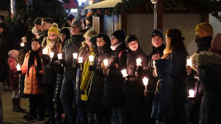 Menschen bilden eine Kette zum Gedenken an die Opfer und Betroffenen des Anschlags auf dem Magdeburger Weihnachtsmarkt. 