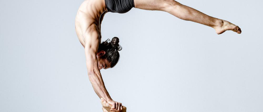 Biegsame Körper. Sie schafft die Basis für seinen Handstand.