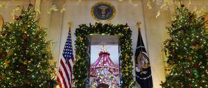Beleuchtete und geschmückte Weihnachtsbäume in der Cross Hall rahmen den Eingang zum Blue Room des Weißen Hauses in Washington ein, wo alles für die Feiertage weihnachtlich geschmückt ist.