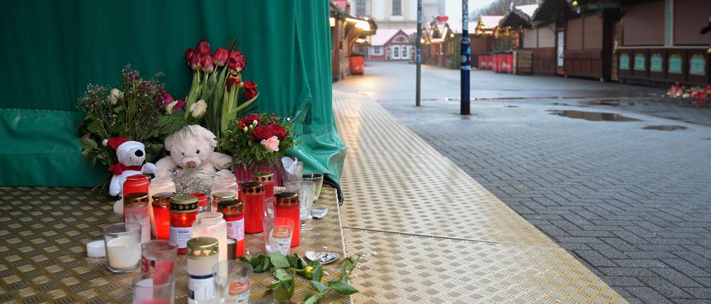 Menschen haben Blumen, Kerzen und Plüschtiere niedergelegt.