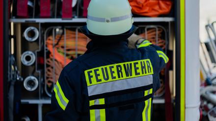 Ein Feuerwehrmann holt Equipment aus einem Einsatzfahrzeug an der Feuerwache der Feuerwehr.