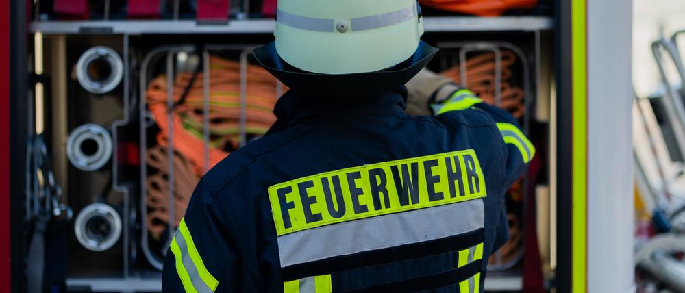 Ein Feuerwehrmann holt Equipment aus einem Einsatzfahrzeug an der Feuerwache der Feuerwehr.