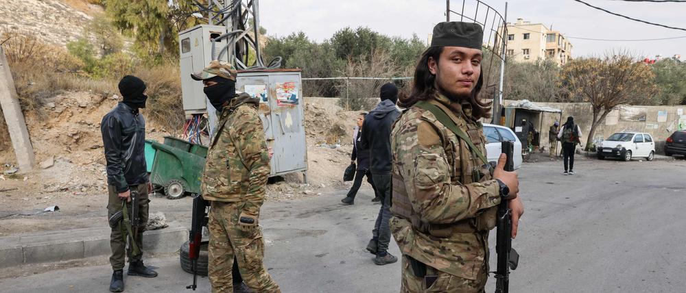 Der neuen syrischen Regierung nahestehende Kämpfer besetzen einen behelfsmäßigen Kontrollpunkt.