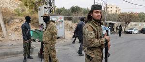 Der neuen syrischen Regierung nahestehende Kämpfer besetzen einen behelfsmäßigen Kontrollpunkt.
