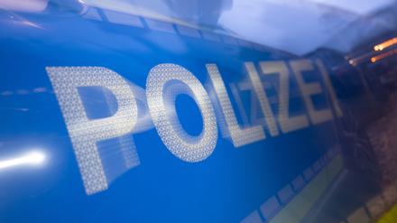 Das Wort Polizei auf der Karosserie eines Polizeifahrzeugs (Symbolbild)