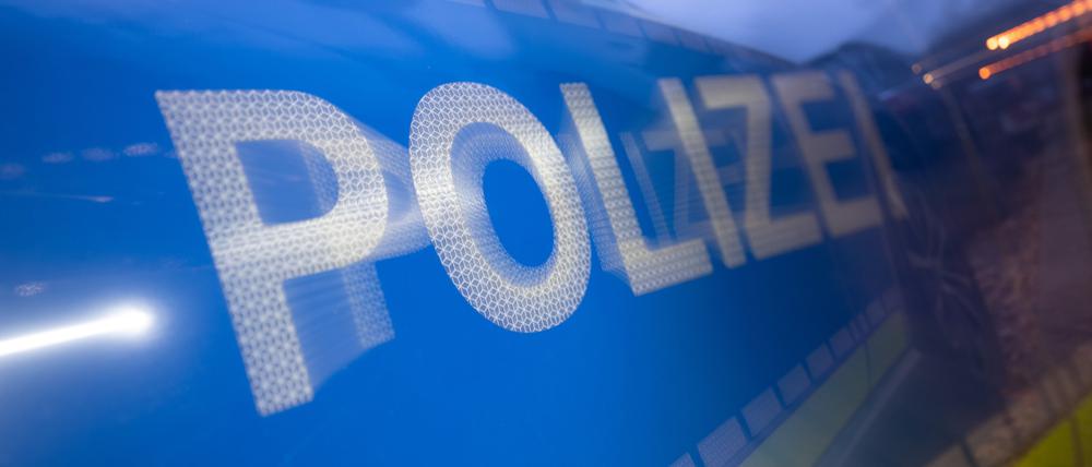 Das Wort Polizei auf der Karosserie eines Polizeifahrzeugs (Symbolbild)