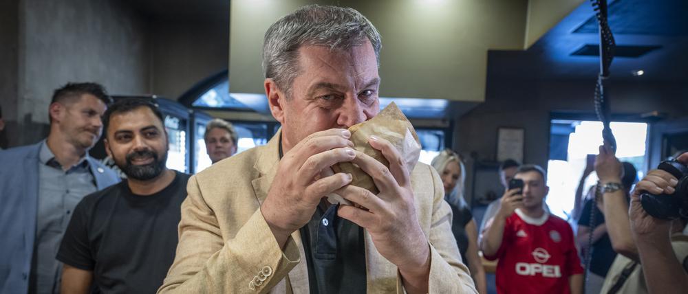 Markus Söder (CSU), Ministerpräsident von Bayern, beißt in einem Dönerlokal in einen frischen Döner.