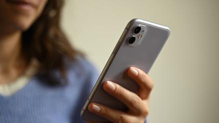 Eine Frau hält ein Smartphone in der Hand.
