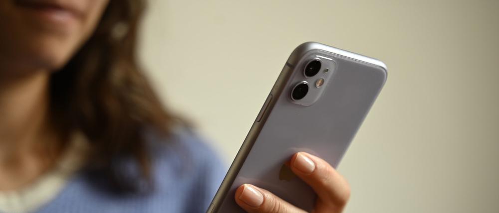 Eine Frau hält ein Smartphone in der Hand.