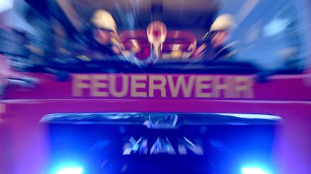 Feuerwehrleute sitzen in einem schnell fahrenden Einsatzfahrzeug. (Symbolbild)