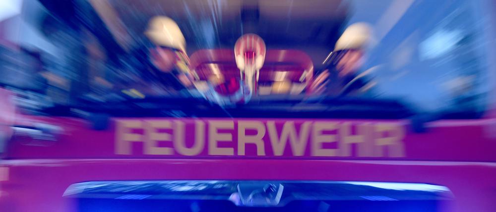 Feuerwehrleute sitzen in einem schnell fahrenden Einsatzfahrzeug. (Symbolbild)