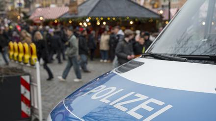 Ein Einsatzfahrzeug der Polizei blockiert die Zufahrt zu einem Weihnachtsmarkt.