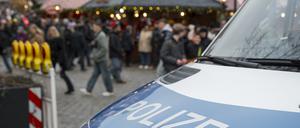 Ein Einsatzfahrzeug der Polizei blockiert die Zufahrt zu einem Weihnachtsmarkt.