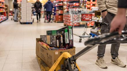 In einem Supermarkt wird ein Karton mit Feuerwerk durch die Regalreihen gefahren. Am heutigen Tag beginnt der Verkauf von Silvesterfeuerwerk. Bis zum Silvestertag werden Böller, Raketen und Feuerwerksbatterien bis zur Kategorie F2 offiziell im Handel angeboten.