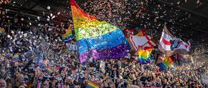 Fans des FC St. Pauli mit Regenbogen-Fahnen und Konfetti  beim Spiel gegen den VfL Wolfsburg.
