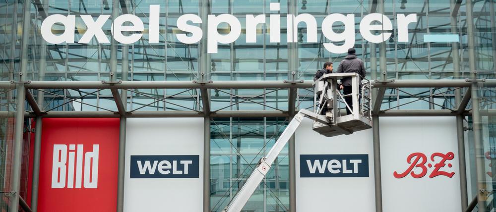 Es rumort in Springers „Welt“. Arbeiter bringen ein neu gestaltetes Logo des Medienkonzerns Axel Springer über der Axel Springer Passage an. Zu dem Medienhaus gehören unter anderem „Bild“, „Die Welt“ und die „BZ“.