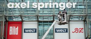 Es rumort in Springers „Welt“. Arbeiter bringen ein neu gestaltetes Logo des Medienkonzerns Axel Springer über der Axel Springer Passage an. Zu dem Medienhaus gehören unter anderem „Bild“, „Die Welt“ und die „BZ“. 