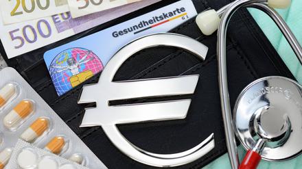 Gesundheitskarte, Geldscheine, Stethoskop und Eurozeichen.