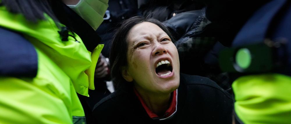 Polizeibeamte führen eine Anhängerin des suspendierten Präsidenten Yoon in der Nähe der Präsidentenresidenz ab.