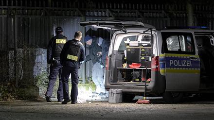 Einsatzkräfte der Polizei untersuchen den Ort einer Explosion außerhalb eines Zauns an einem Polizeigelände in Berlin-Wittenau. Bei der Explosion eines unbekannten Gegenstandes am Zaun eines Polizeigeländes in Berlin-Wittenau sind am Abend ein Polizist und dessen Kollegin teils schwer verletzt worden. 
