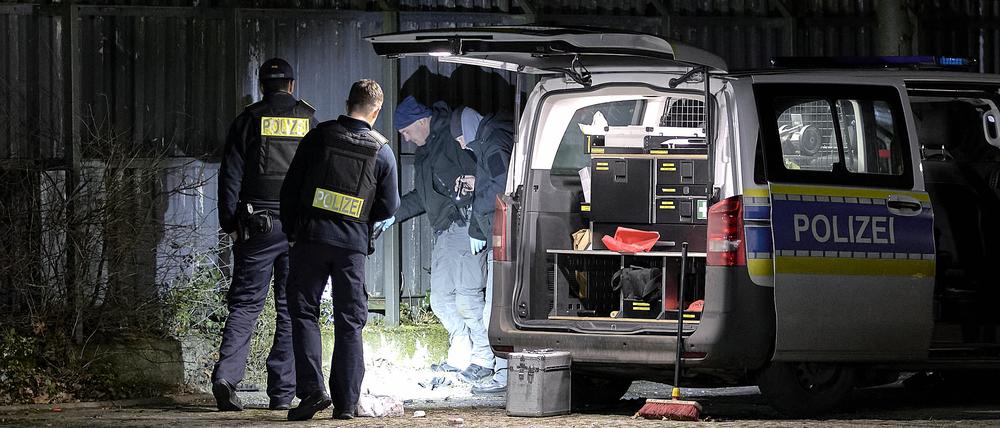 Einsatzkräfte der Polizei untersuchen den Ort einer Explosion außerhalb eines Zauns an einem Polizeigelände in Berlin-Wittenau. Bei der Explosion eines unbekannten Gegenstandes am Zaun eines Polizeigeländes in Berlin-Wittenau sind am Abend ein Polizist und dessen Kollegin teils schwer verletzt worden.