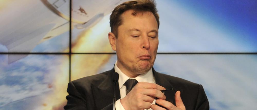 SpaceX founder and chief engineer Elon Musk looks at his mobile phone during a post-launch news conference to discuss the SpaceX Crew Dragon astronaut capsule in-flight abort test at the Kennedy Space Center in Cape Canaveral, Florida.
