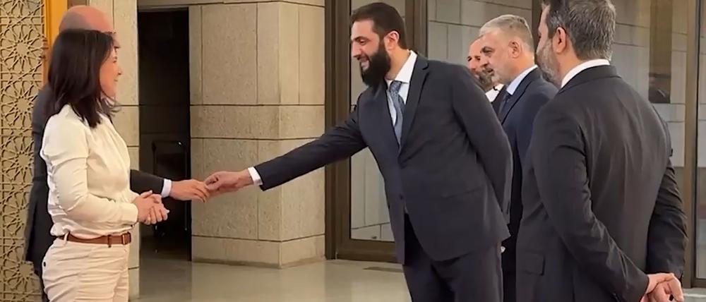 Ausgestreckte Hand nur für den männlichen Minister: Rebellenchef al-Scharaa. 