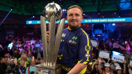 Luke Littler und die Sid Waddell Trophy für den PDC-Dartsweltmeister.