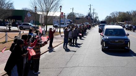 Trauernde versammeln sich, als der Leichenwagen mit dem in die Flagge gehüllten Sarg des ehemaligen US-Präsidenten Jimmy Carter am 4. Januar 2025 durch Ellaville, Georgia, fährt. 