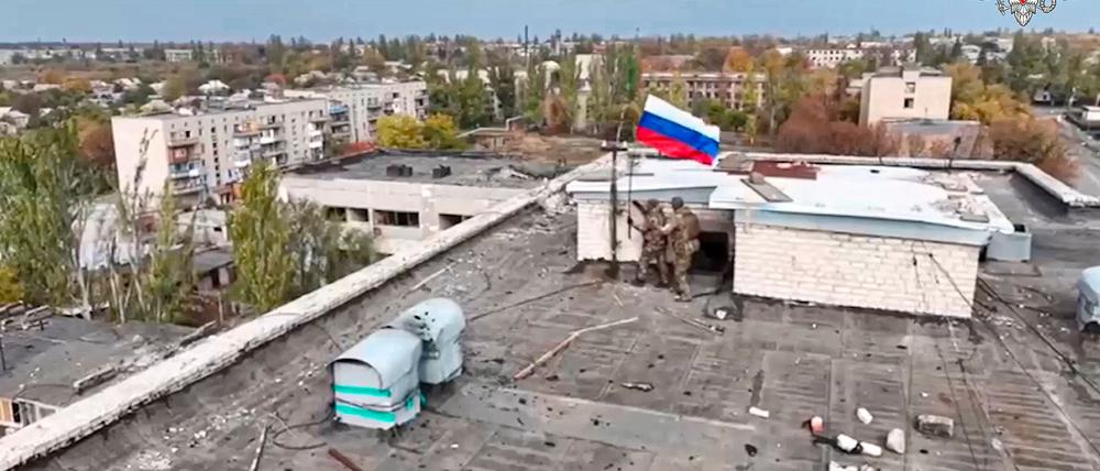 Russische Soldaten hissen in einer Ortschaft auf einem Gebäude eine Fahne nach dessen Einnahme. (Archivbild/Handout) 