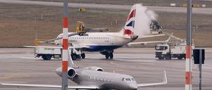 Ein Flugzeug wird am Flughafen BER vom Eis befreit. Der Hauptstadtflughafen begrenzt die Zahl der Ankünfte vorsorglich. 