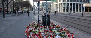 Blumen und Kerzen stehen im Gedenken an die Anschlagsopfer an einer Straßenbahnhaltestelle auf dem Breiten Weg in Magdeburg.