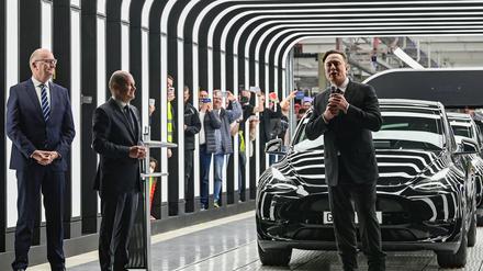 22.03.2022, Brandenburg, Grünheide: Dietmar Woidke (l, SPD), Ministerpräsident des Landes Brandenburg, Bundeskanzler Olaf Scholz (M, SPD) und Elon Musk, Tesla-Chef,  nehmen an der Eröffnung der Tesla-Fabrik Berlin Brandenburg teil. Die erste europäische Fabrik in Grünheide, die auf 500 000 Fahrzeuge jährlich ausgelegt ist, ist eine wichtige Säule der Zukunftsstrategie von Tesla. Foto: Patrick Pleul/dpa-Zentralbild POOL/dpa +++ dpa-Bildfunk +++