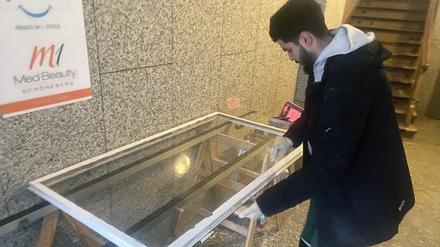 Glaser Firat Dogan setzt eine neue Scheibe in ein altes Kastenfenster ein.