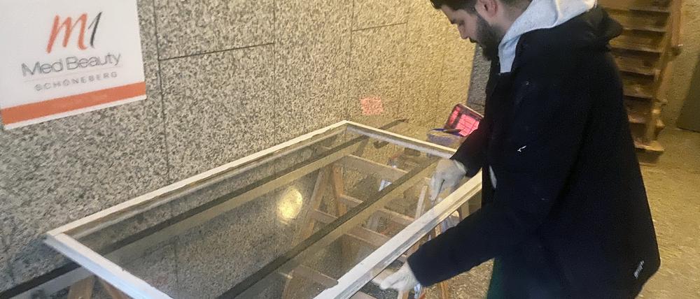 Glaser Firat Dogan setzt eine neue Scheibe in ein altes Kastenfenster ein.