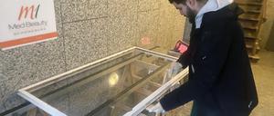 Glaser Firat Dogan setzt eine neue Scheibe in ein altes Kastenfenster ein.