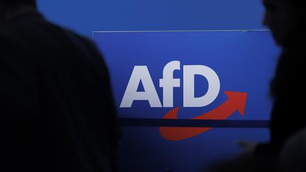 Delegierte gehen vor dem Parteilogo bei dem AfD-Bundesparteitag in Magdeburg.
