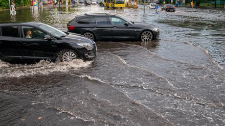 Autos fahren über die überflutete Tiergartenstraße in Berlin Mitte.