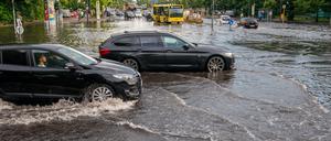 Autos fahren über die überflutete Tiergartenstraße in Berlin Mitte.