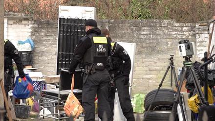 Polizisten durchsuchen ein Grundstück in Berlin-Wannsee. 