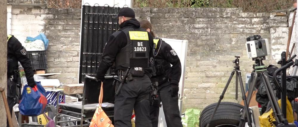 Polizisten durchsuchen ein Grundstück in Berlin-Wannsee. 