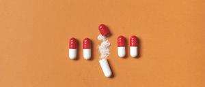Fünf Tabletten mit Vitaminpulver (Illustration).