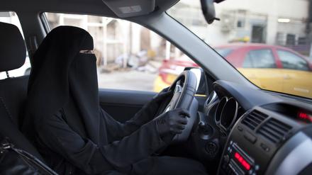 Eine verschleierte Frau fährt Auto.