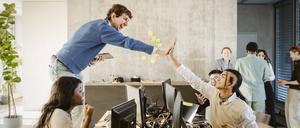 Hippe Start-Up-Mitarbeitende geben sich ein High-Five. 