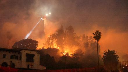 Ein Hubschrauber wirft Wasser über dem Hollywood-Viertel von Los Angeles ab.
