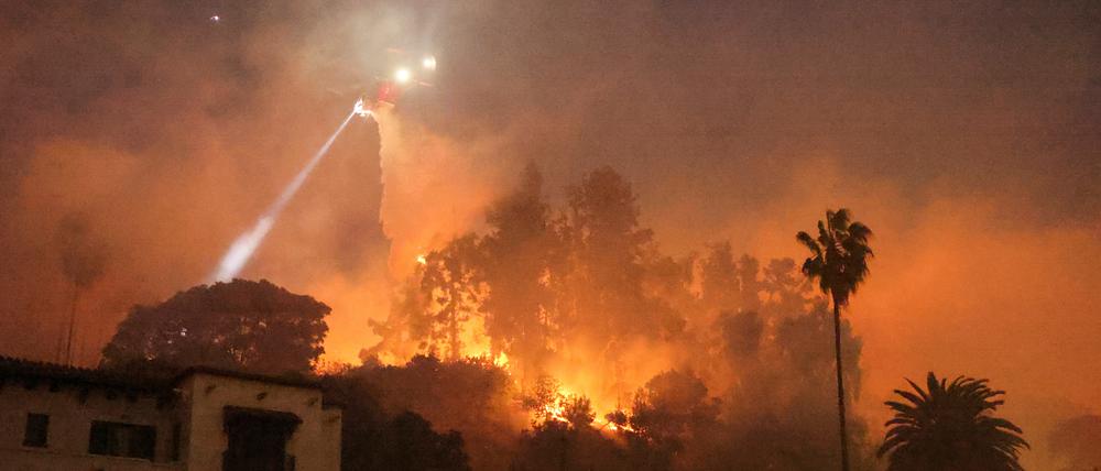 Ein Hubschrauber wirft Wasser über dem Hollywood-Viertel von Los Angeles ab.