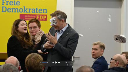 Der FDP-Vorsitzende Christian Lindner (M) bekommt bei einem Wahlkampfauftritt in Greifswald Schaum ins Gesicht. Er war von einer jungen Frau mit Schaum beworfen worden. Sie traf den früheren Finanzminister dabei direkt ins Gesicht. Nach dem Vorfall setzte er seine Rede fort. (Screenshot aus einem Video). 